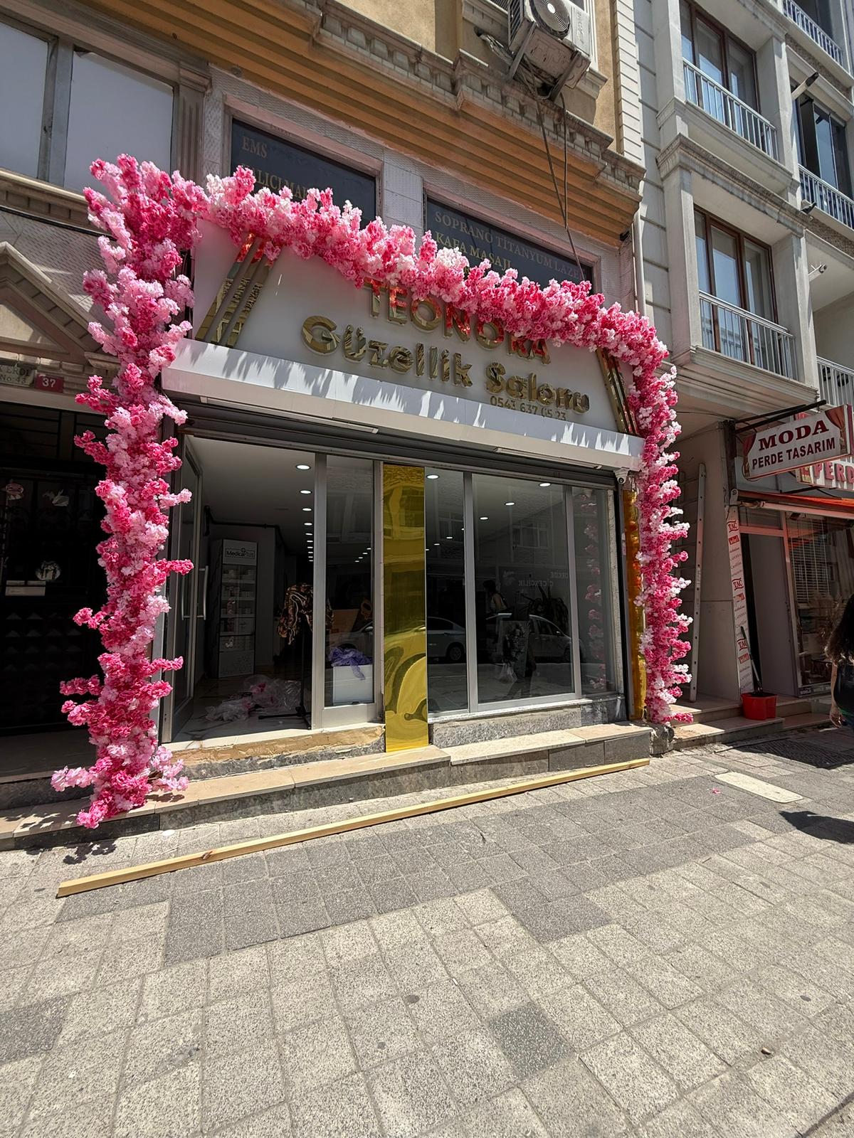 Mağaza girişi pembe yapay çiçek takı ve dış mekan dekorasyonu uygulaması